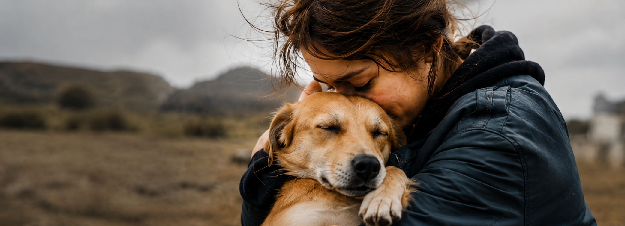 Bir gönüllü, kurtarılmış bir köpeğe sarılıyor